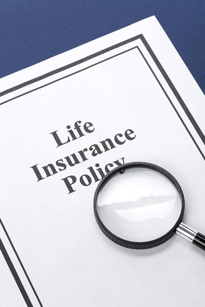 life insurance policy written on a paper with a magnifying glass