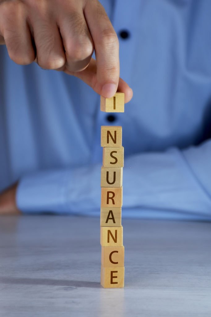 Insurance concepts. Hand arranging wood blocks and word of insurance written on the wood blocks