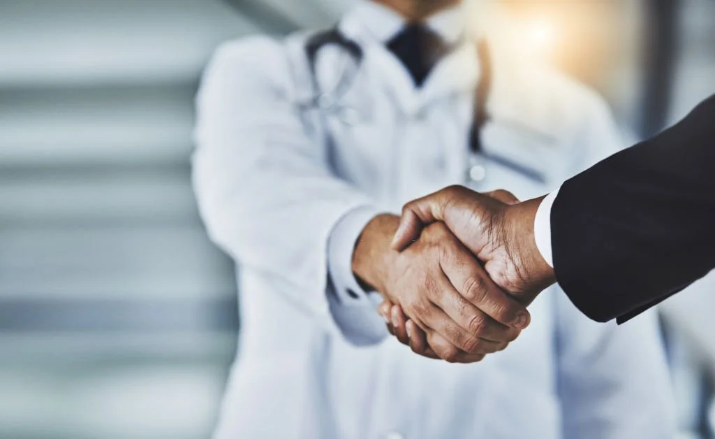 A manager shaking hands with a doctor