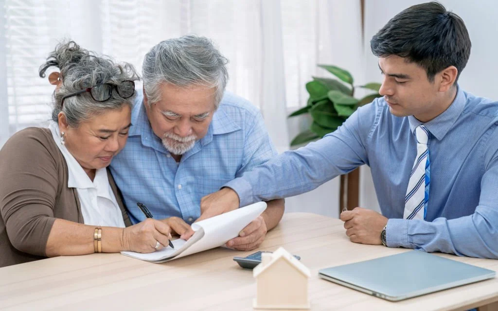 Health insurance broker helping out an old couple fill a form